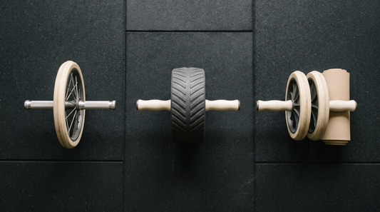 Three ab roller wheels laid in a row on gym flooring