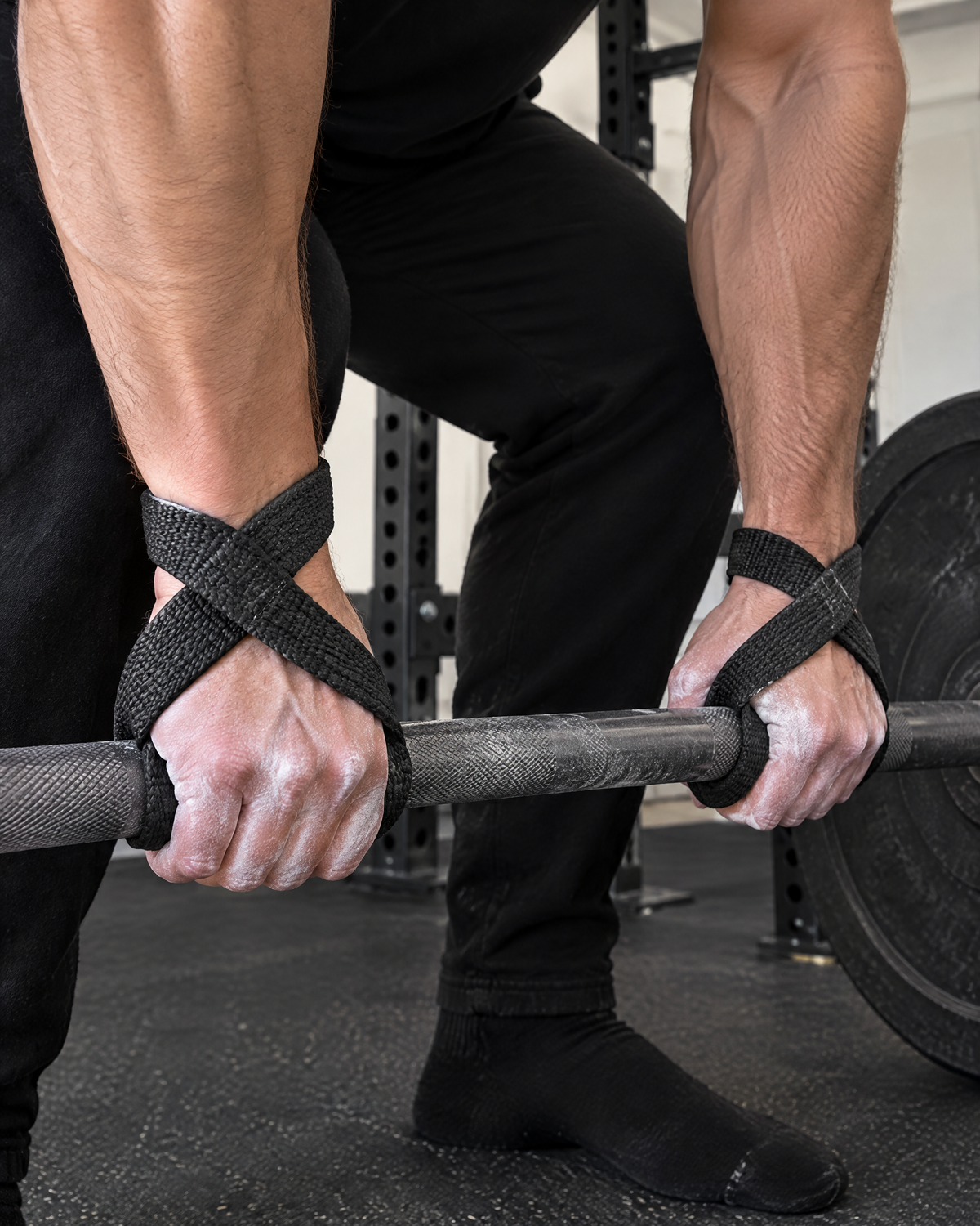 Lifter using black figure 8 lifting straps on a heavy barbell deadlift