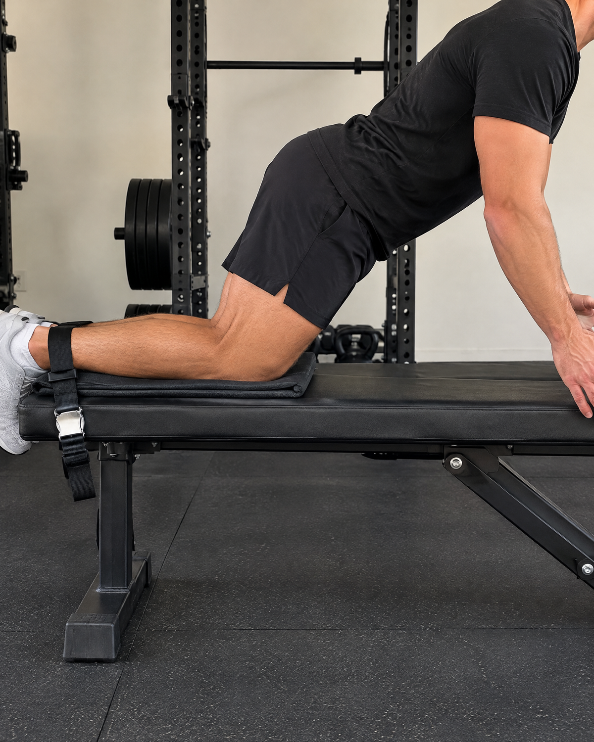 Athlete doing a Nordic hamstring curl with ankles strapped to a flat bench