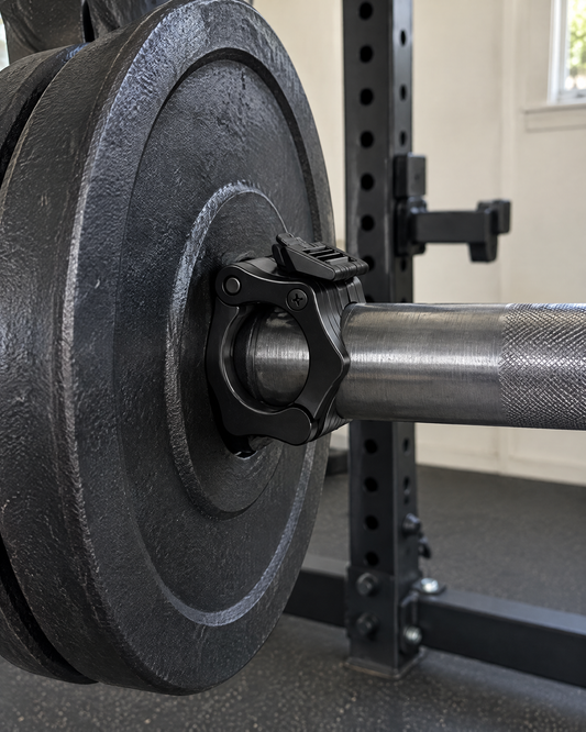 Single black quick-lock barbell collar locked on an olympic bar in a home gym