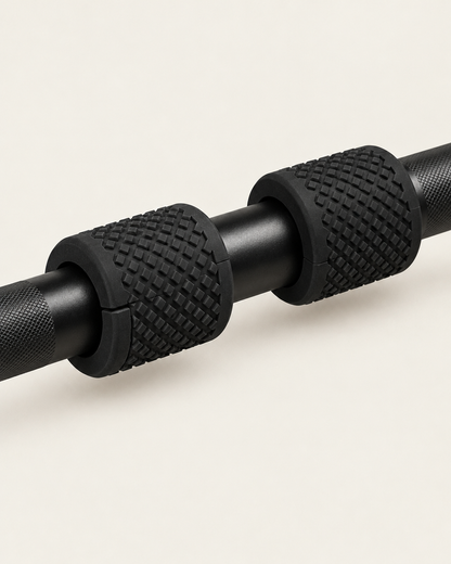 Pair of black fat grips clamped on a barbell showing the split that slides over the bar