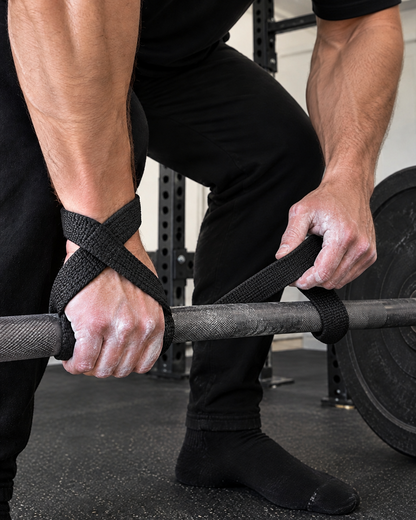Wrapping a figure 8 lifting strap under a barbell before a deadlift