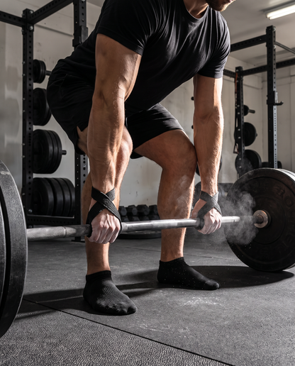 Lifter mid-deadlift using figure 8 straps on a loaded barbell