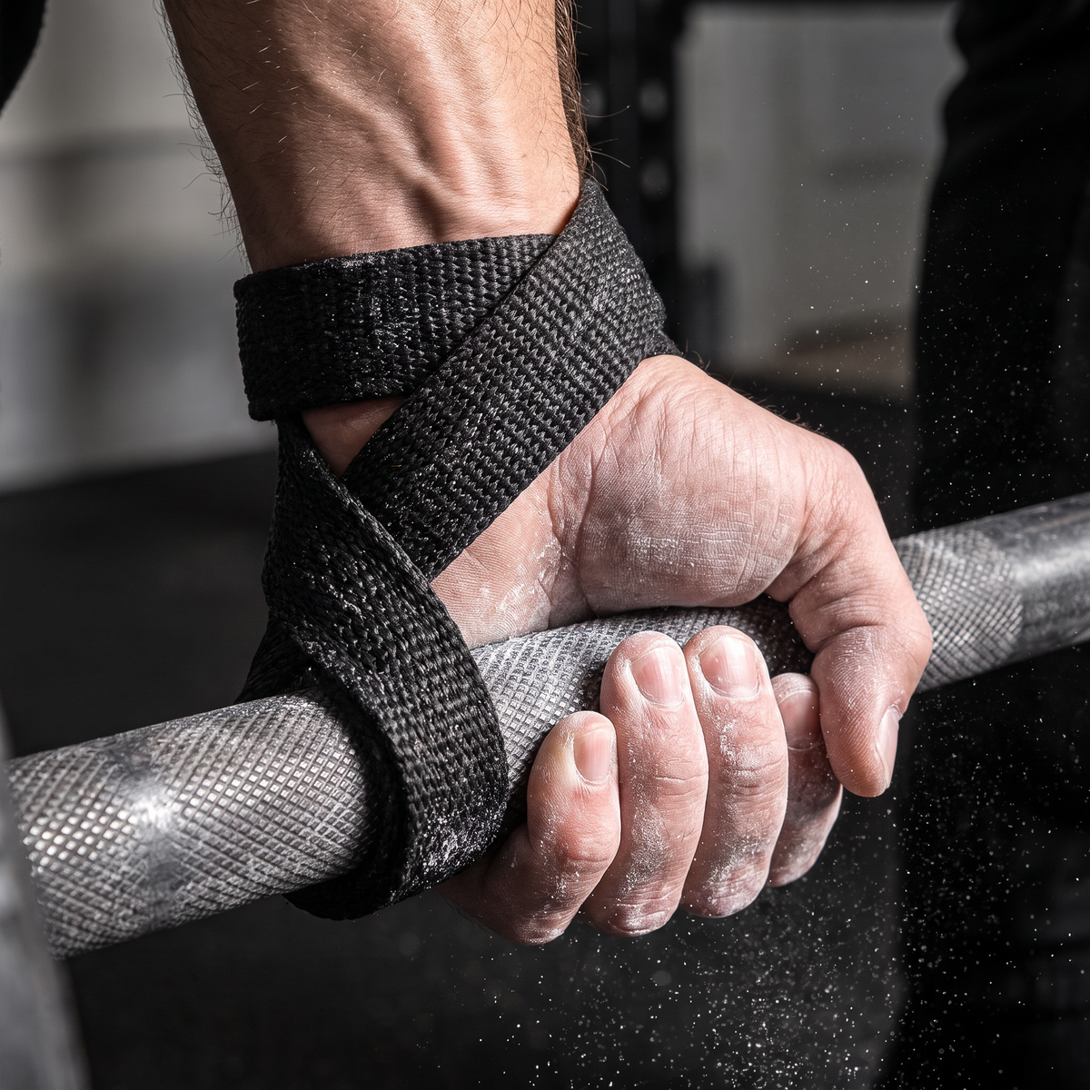 Figure 8 lifting strap cinched around a wrist gripping a barbell