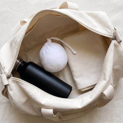 Gym chalk ball packed in a gym bag with a water bottle and towel