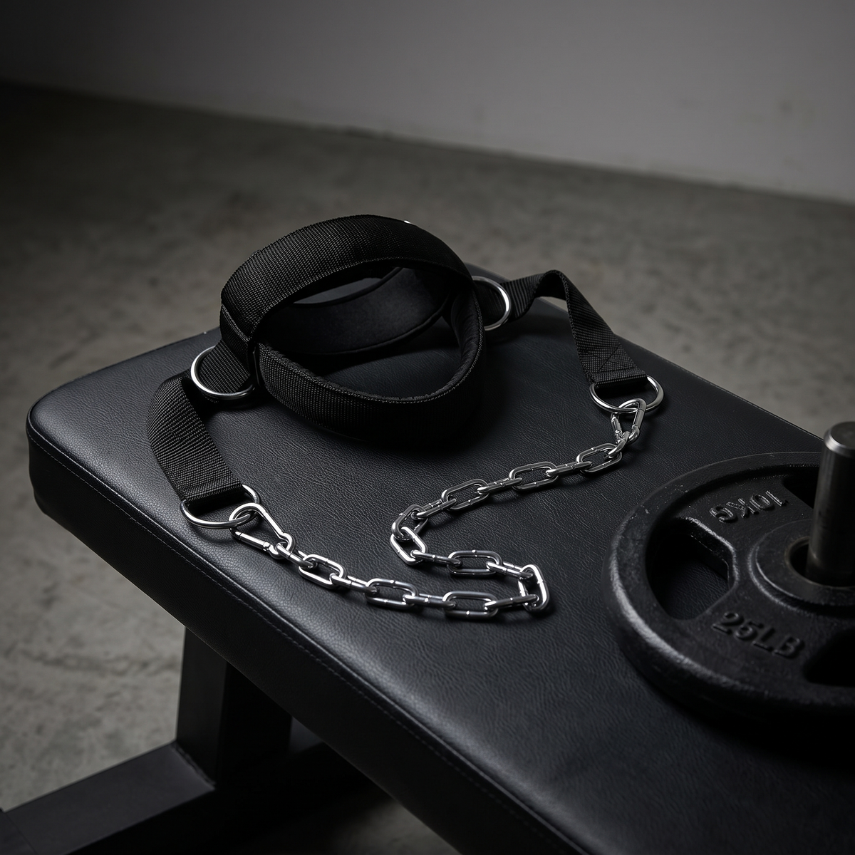 Neck harness with steel chain on a weight bench