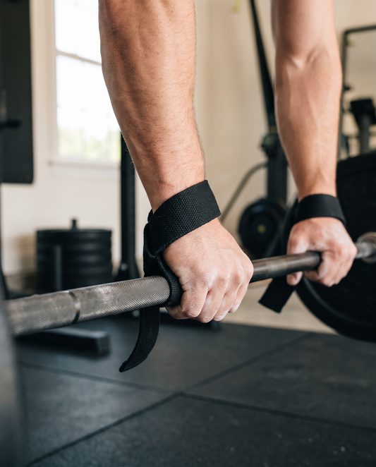 Black lasso lifting straps wrapped around the wrists and a barbell during heavy rows